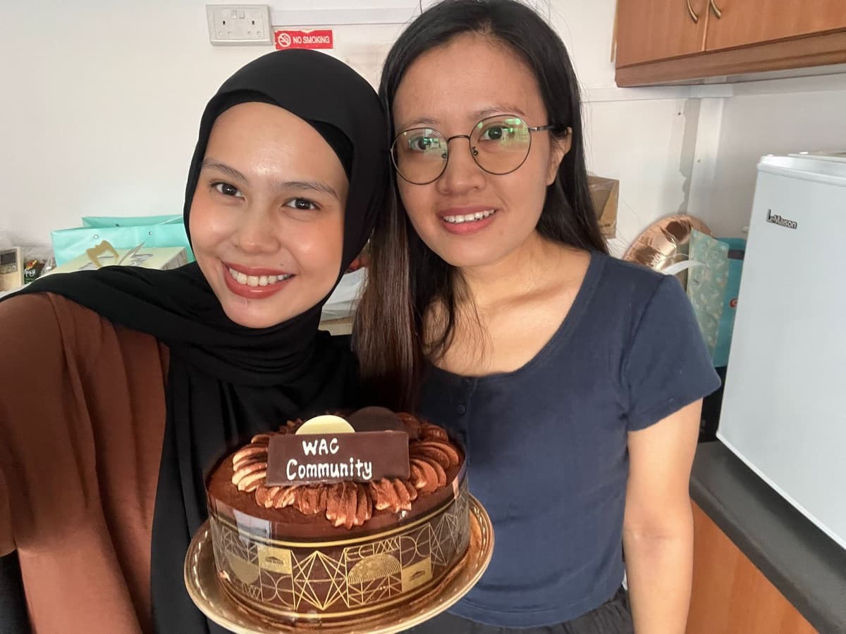 Two friends with a WAC Community birthday cake