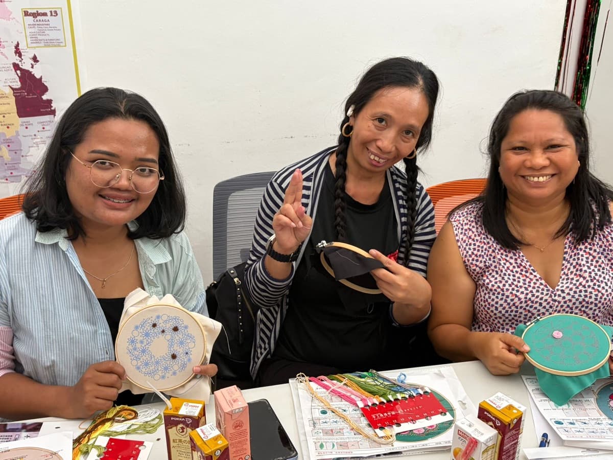 Helpers showing their work at an embroidery workshop