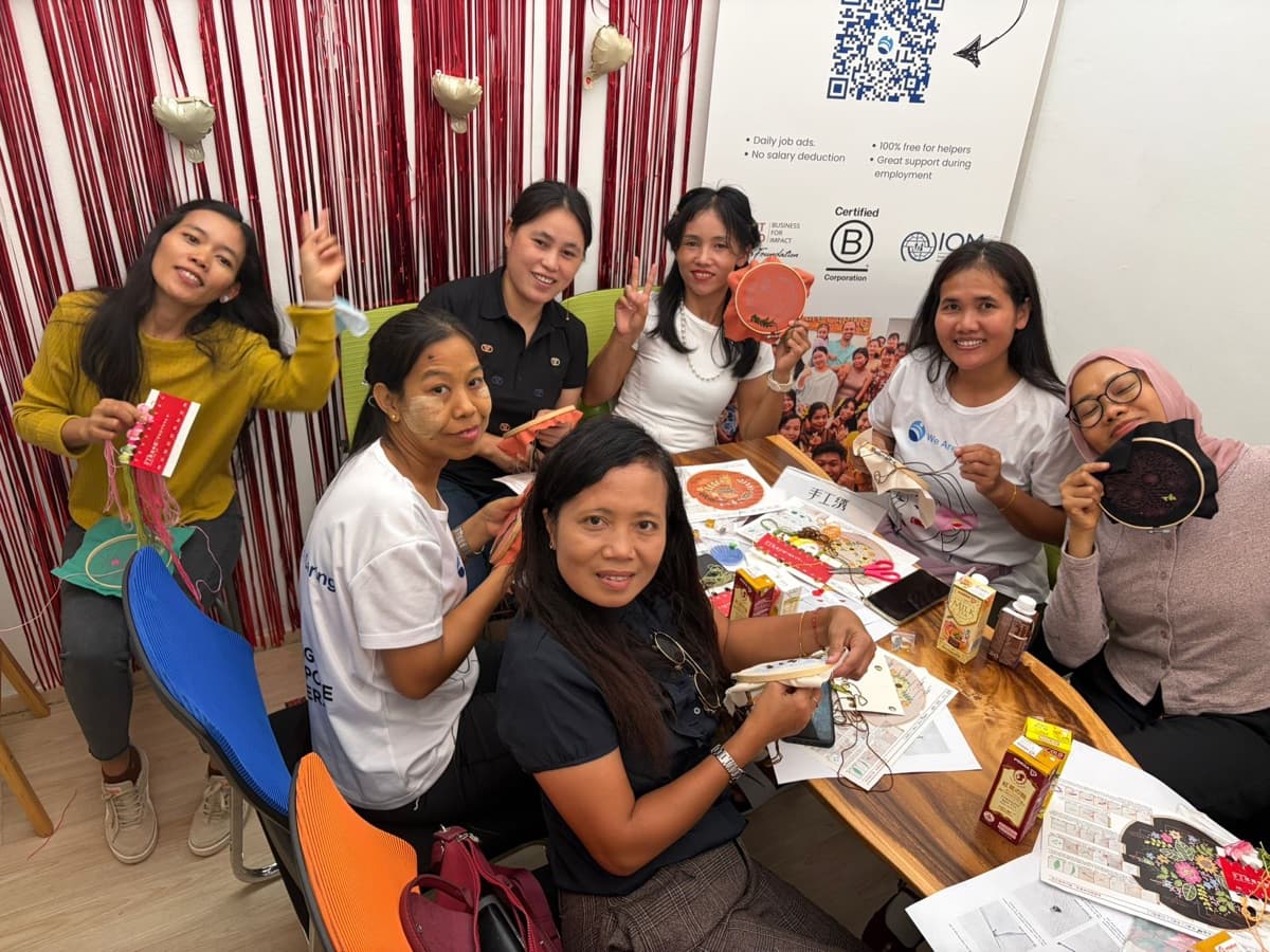Helpers around a table at an embroidery workshop