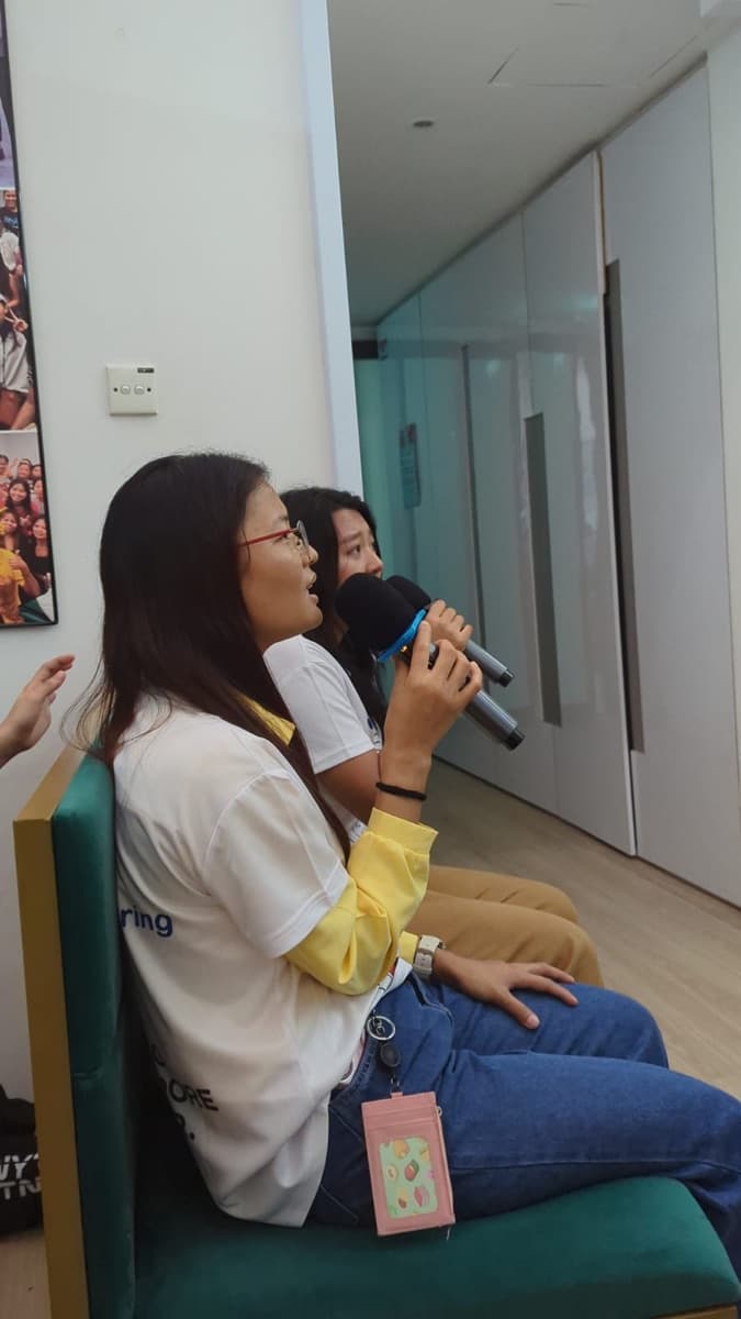 A helper singing karaoke at a Sunday gathering