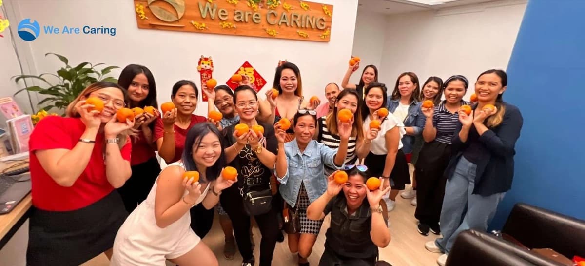 Helpers holding mandarin oranges at Lunar New Year