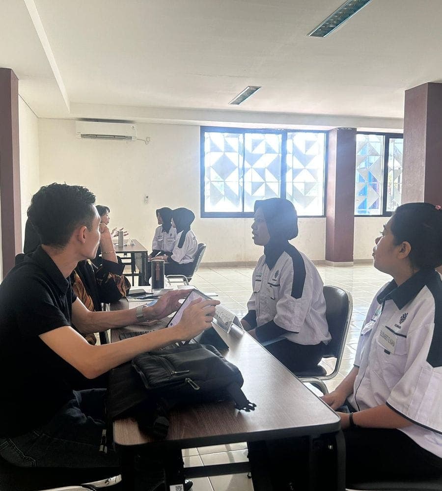 Caregivers in uniform interviewed by a Singapore agency across a table