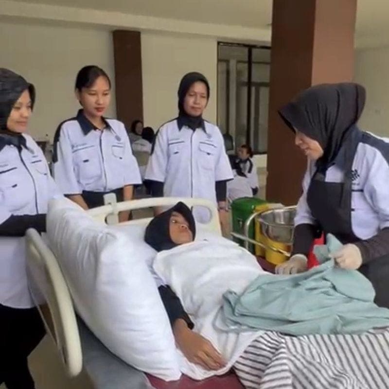 Trainee caregivers practising care for a bed-bound person