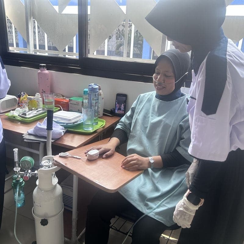 A trainee caregiver fitting an oxygen cannula