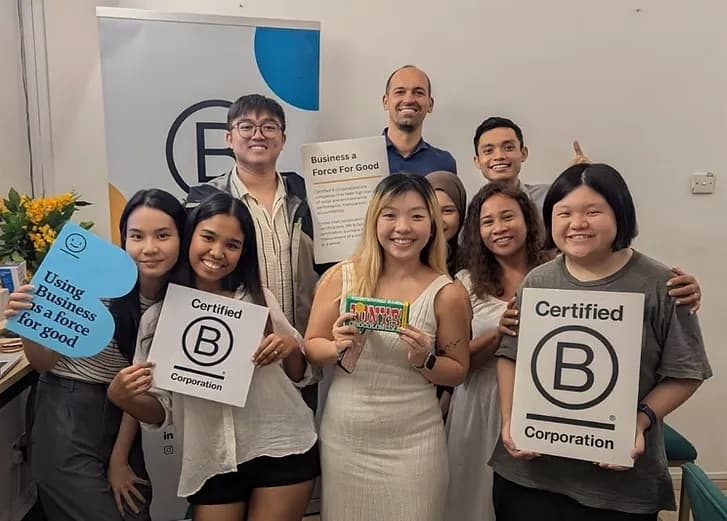 The We Are Caring team holding B Corp boards