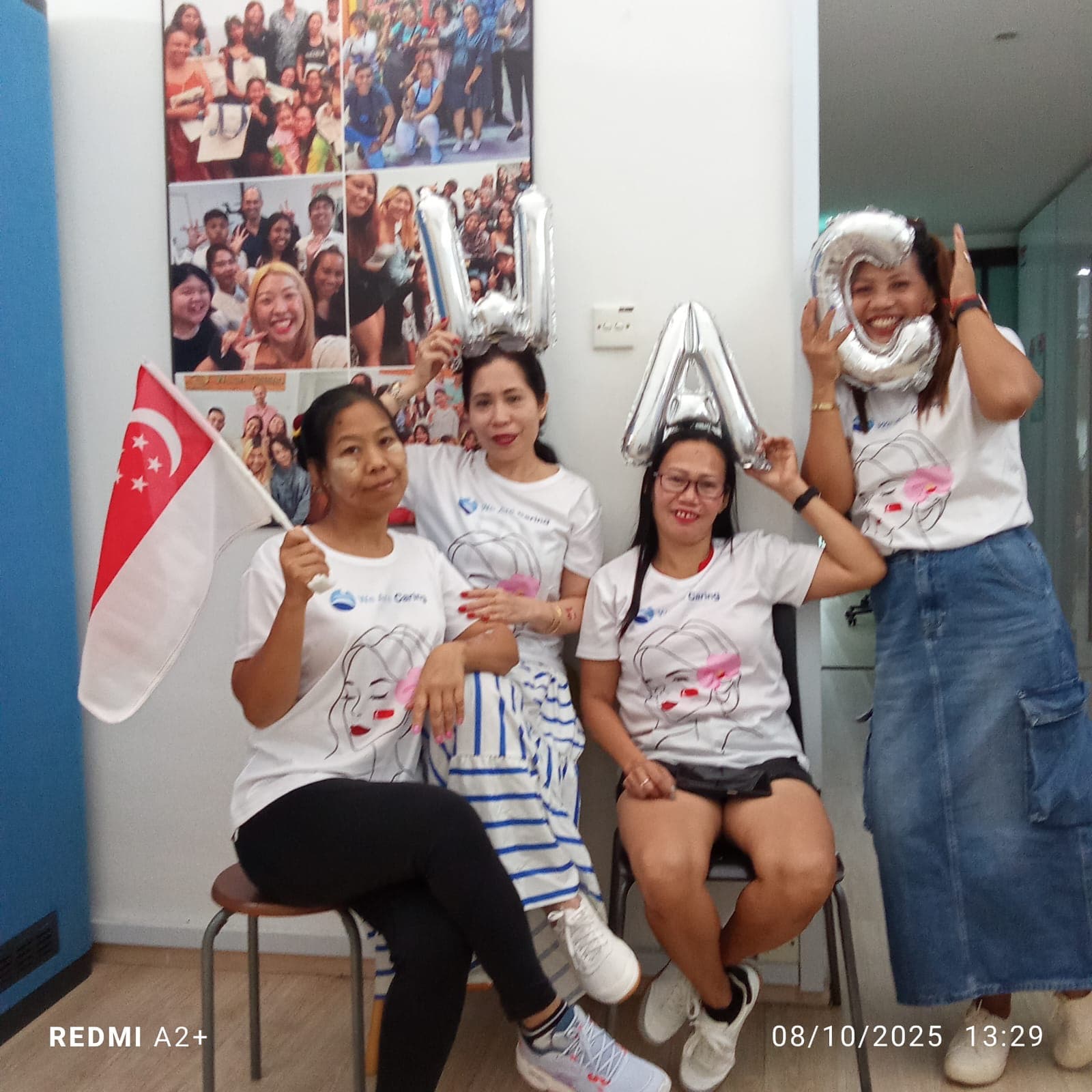 Helpers with We Are Caring balloons at the office