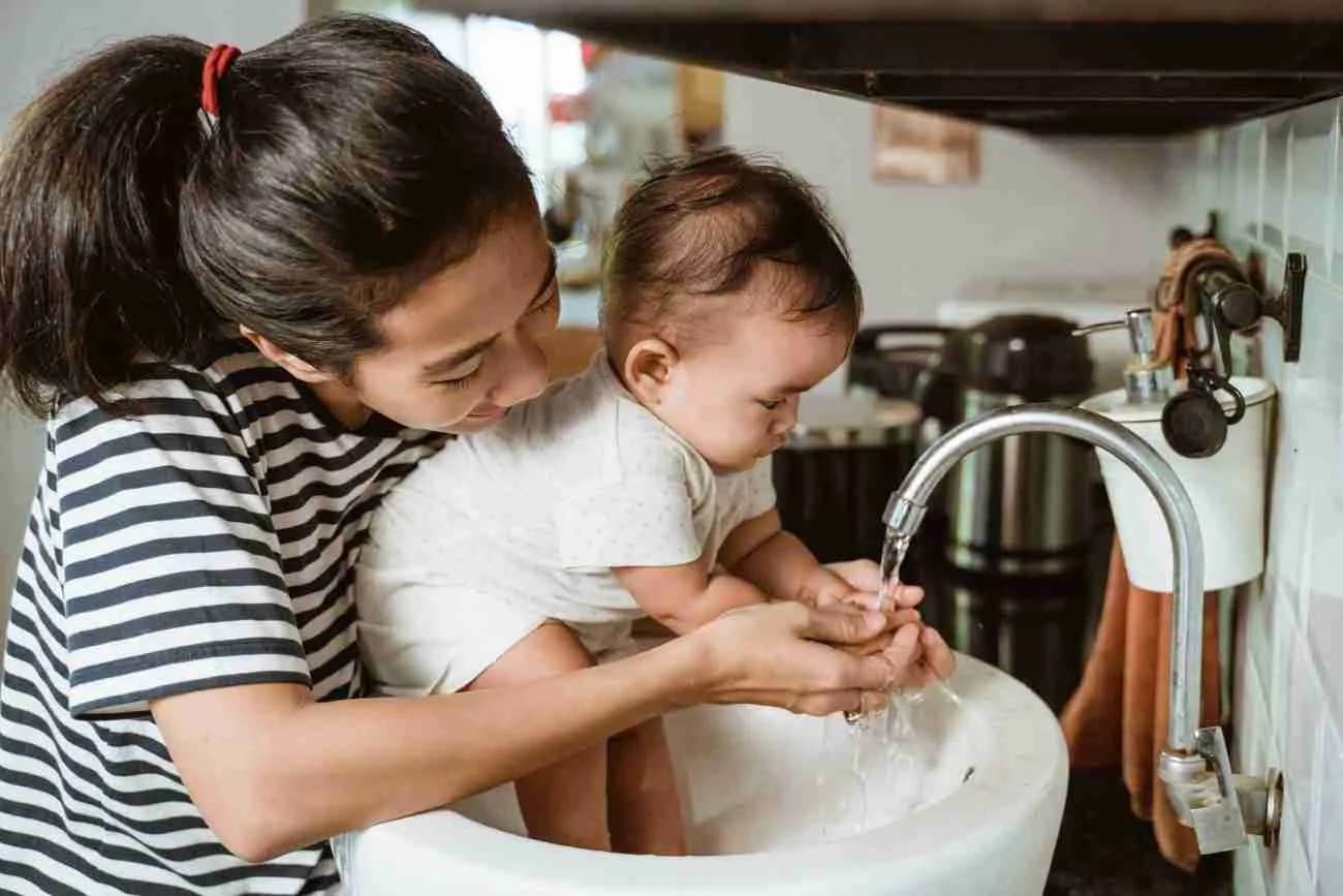 A helper and a baby playing with water