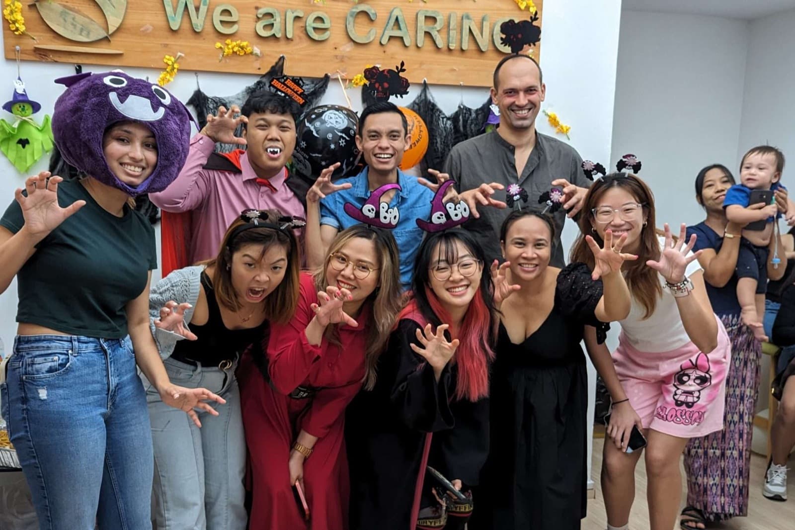 The We Are Caring team and helpers at a Halloween celebration in the office